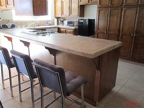 This is a breakfast counter area shown across from large cupboards in the kitchen.