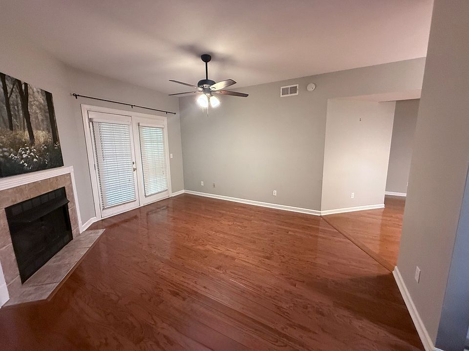Open living room with vaulted ceilings and door to covered patio