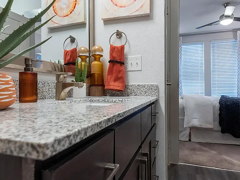 Dual Vanities With Granite Countertops and Bedroom Access