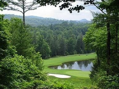 View the 8th fairway, green and pond with the mountains in the background