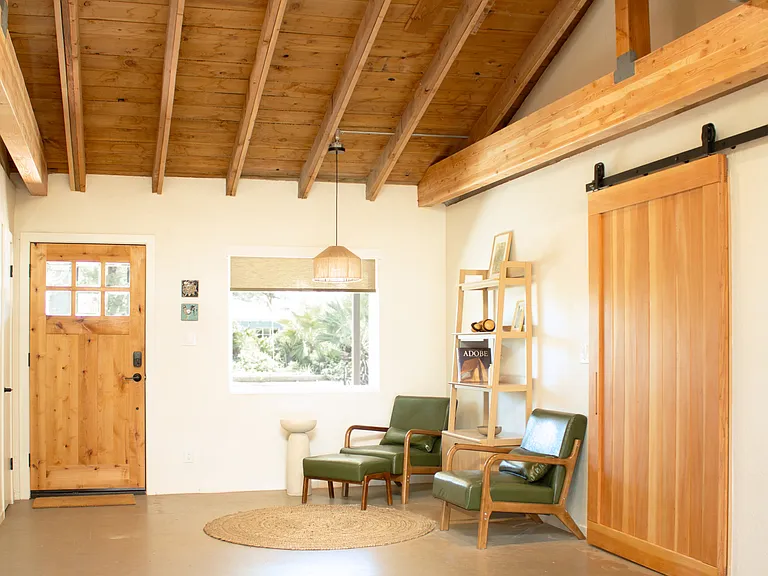 Welcoming entry with exposed beams and seating area.