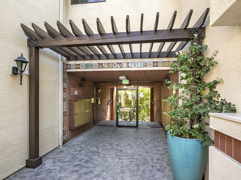 Apartments in Encino, CA - Exterior Walkway with Pergola and Covered Mailbox Area
