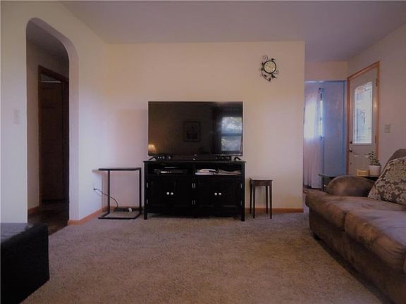 The opposite view of the Living Room with Main Entry shown on the right (Dining Room and Kitchen beyond) and the Rear Hallway to