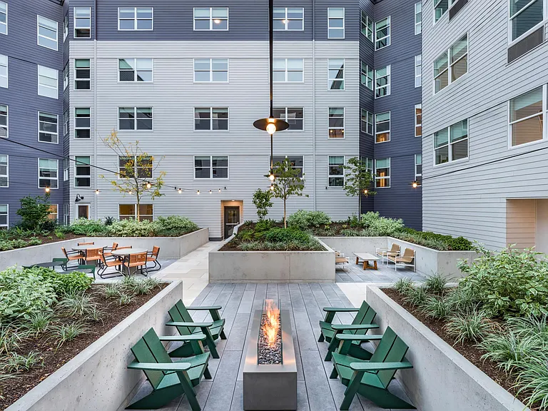 Relax in Modera Woodstock's lush landscaped courtyards with cozy lounge seating and a stylish fire table.