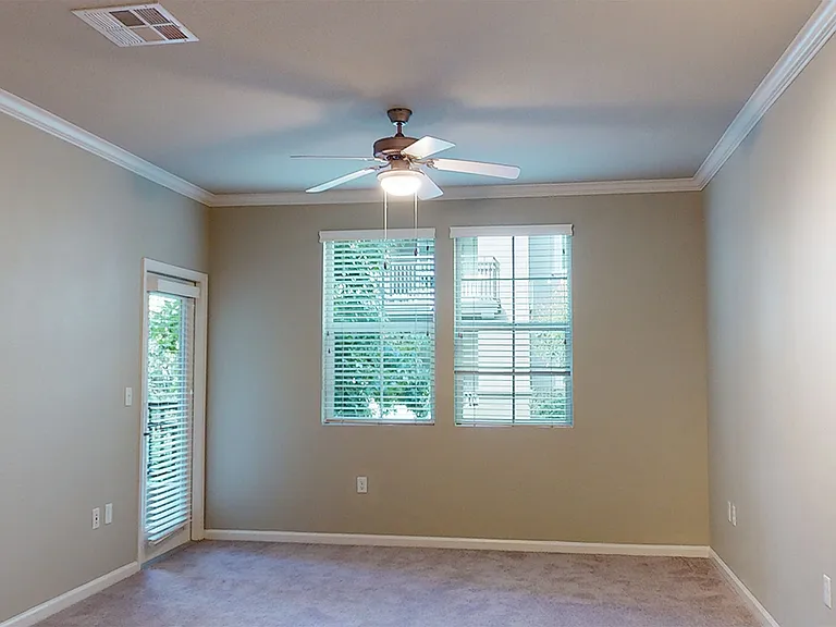 Apartment living room with plush carpet flooring.