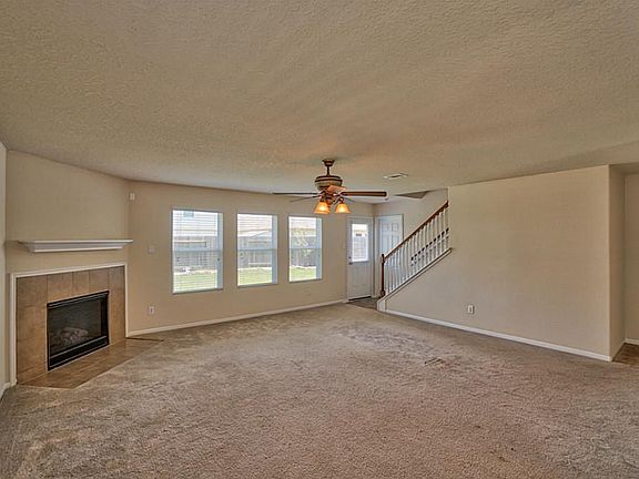 Upgraded optional stairway banister , ceiling fan and gas fire place with wall of windows to the backyard !