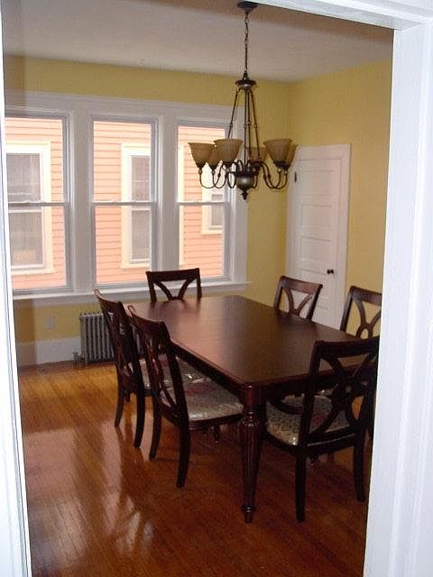 Oversized dining room with mahogany inlaid flooring. Room has a new light fixture and has since been painted a more neutral color.