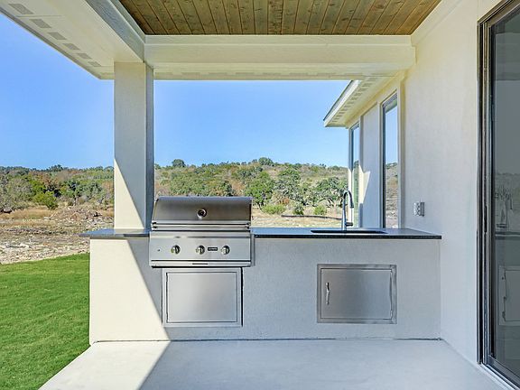 The covered patio of the Timberline plan has a built-in grill