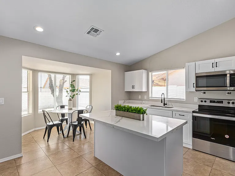 This bright and spacious kitchen features an open floor plan that seamlessly blends into the charming dining nook.