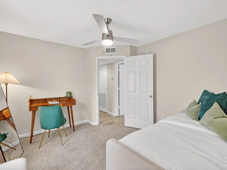 Spacious bedrooms with overhead lighting and ceiling fan.