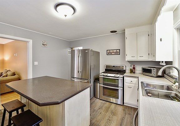 Island has corian counter top, double oven, refrigerator with french doors