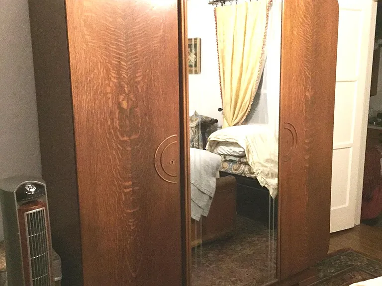 large Amoire with two doors that have hanging within & the last door has shelving