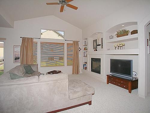 Kitchen opens directly into large living room with built-ins and gas fireplace