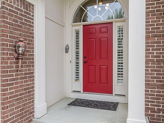 Courtyard entry with a freshly painted front door.  3 car garage w epoxy flooring.