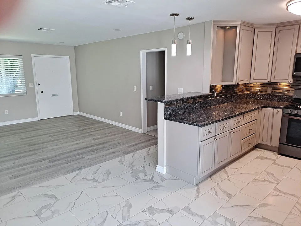 Custom tile floors and new laminated wood flooring with downlights on a dimmer. Accent lighting above bar-top counter off kitchen counter.