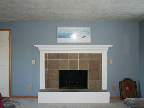The living room central focus is on this beautiful fireplace and a large Bay window off to the right