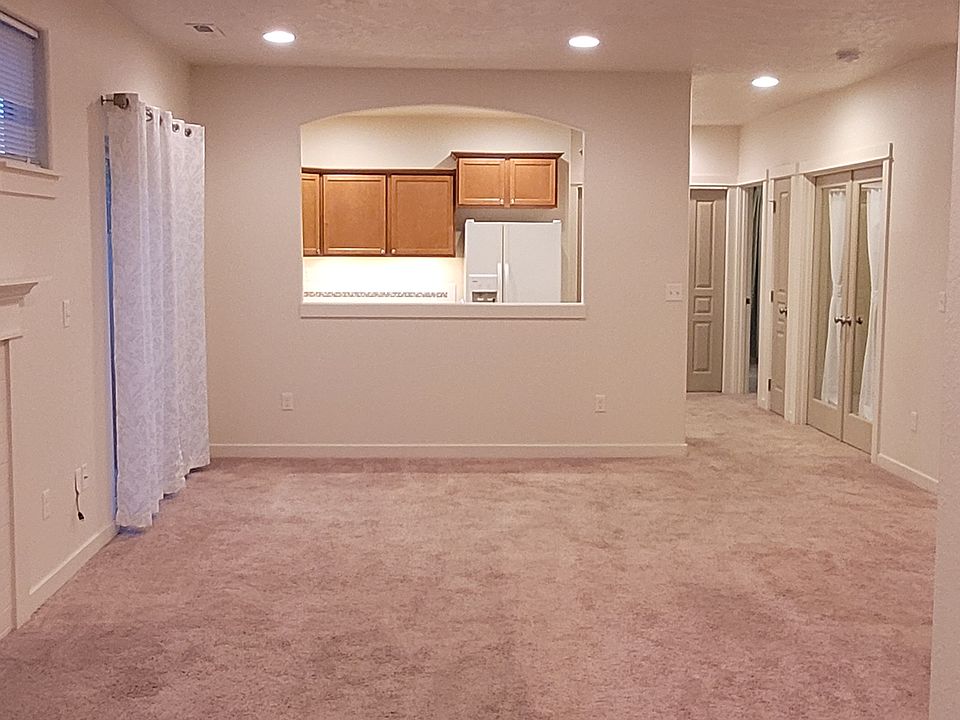 Living Room view from front door entry with cut-out window to the kitchen; sliding door & gas fireplace on left