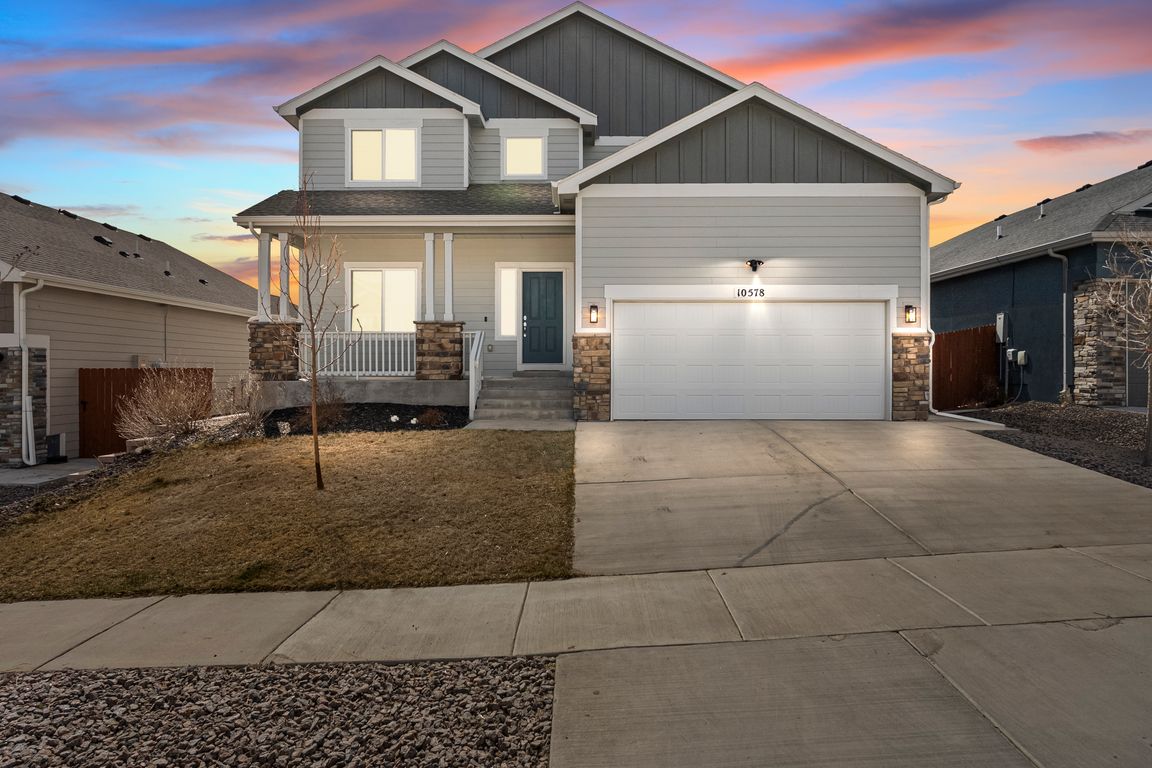 Craftsman inspired home featuring covered porch, stone siding, and concrete driveway