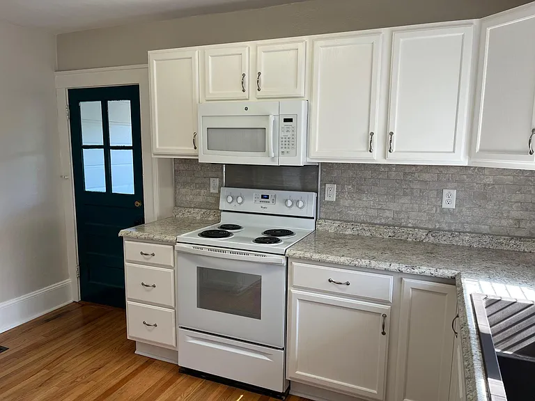 Peacock colored door leads to laundry room and half bath.