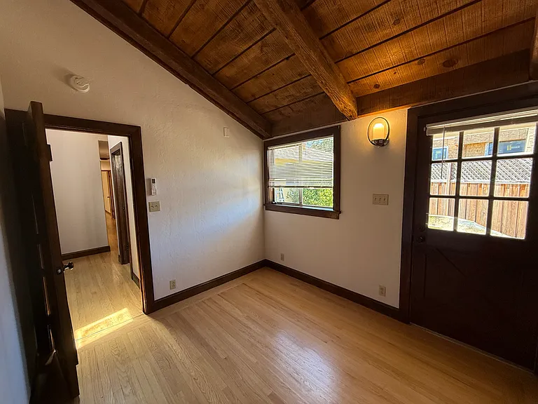 Bedroom #4 features wooden valuted ceiling, one window, patio door to backyard and 2 closets with a split AC cooling unit.