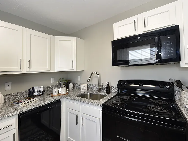 Kitchen with granite counters, modern cabinetry, and black appliance package