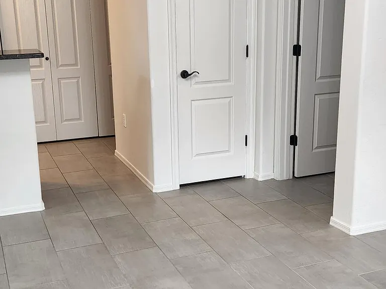 living room looking toward kitchen on left and primary bedroom door on right