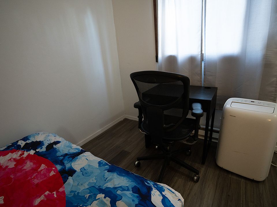 Living room space with room for a desk, or other furniture as well as an AC unit