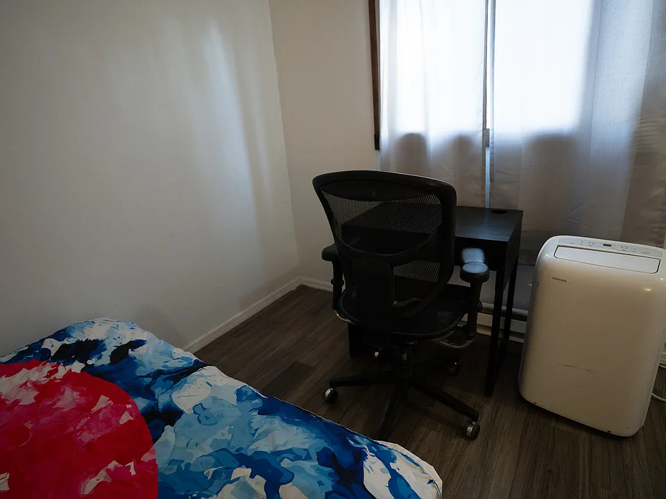 Living room space with room for a desk, or other furniture as well as an AC unit
