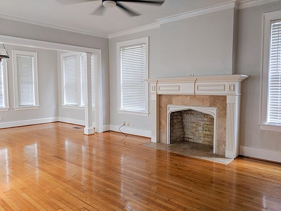 Large living room + sunroom with beautifully detailed mantel. Fireplace is not operable.