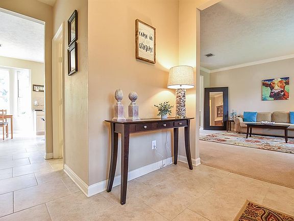 As you enter the home, you'll notice the upgrade tile in the entry and leading into the kitchen area. On the right is the spacious living area.