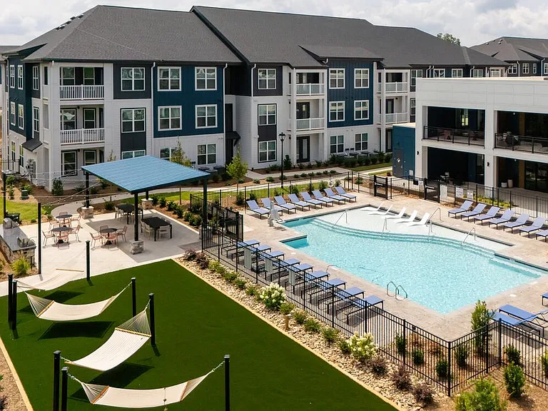 Courtyard with pool, sundeck, grills, lounge seating, and hammock lawn