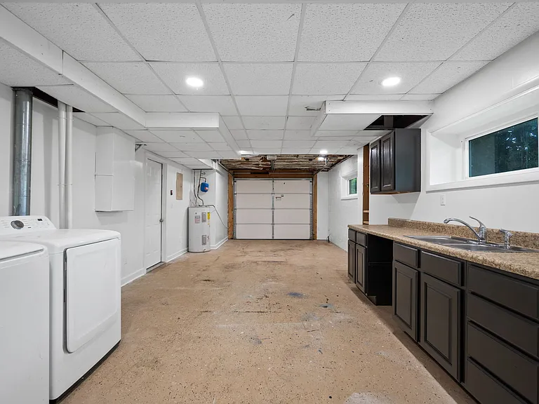 Garage / Laundry located downstairs with a sink and folding station set up or can be used as a 2nd kitchen