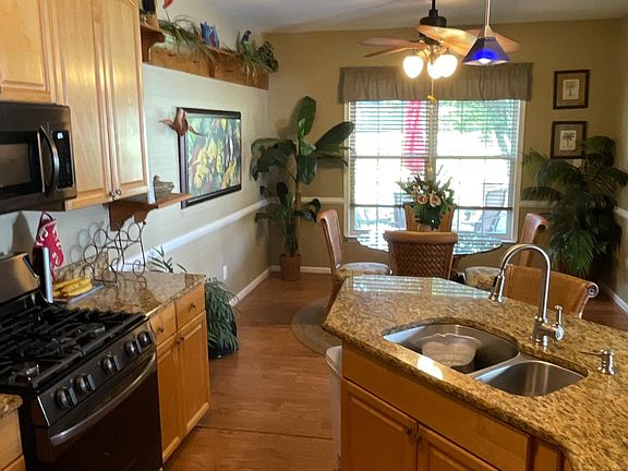 Modern kitchen with all new appliances in black stainless steel. Granite countertops, wood laminate flooring.