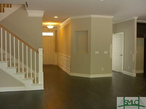 VIEW FROM FAMILY ROOM: ENTRY WAY FOYER WITH TRIM PACKAGE, STAIRWAY WITH WOOD STAINED RISES AND WHITE SPINDAL RAILING, HARDWOOD F