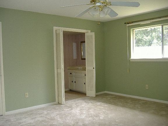 large master with ceiling fan and walk-in closet