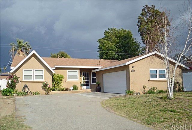 Front of house with Rv/Boat parking (to the left) and 2 car attached garage.
