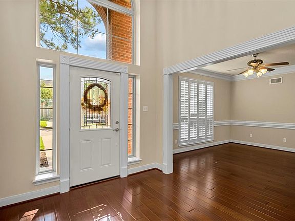Front entrance with large Lunette window bringing lots of natural light into the home. Dining room to the right.