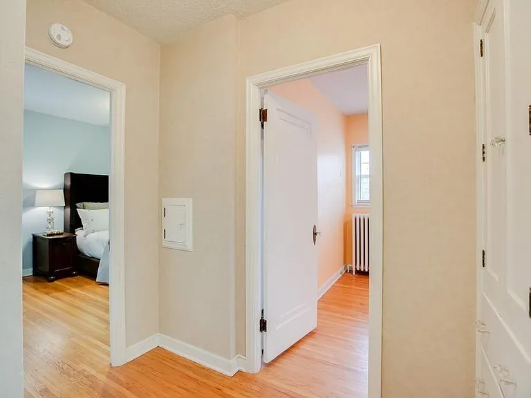 Hallway with laundry storage, looking into main bedroom (left) and 2nd Bedroom/Office. Corner with white panel (obsolete) fits 24"w x 15"d X 51" tall IKEA dresser/medicine chest. Main bedroom has large closet with two tiers of Elfa shelving, and door that