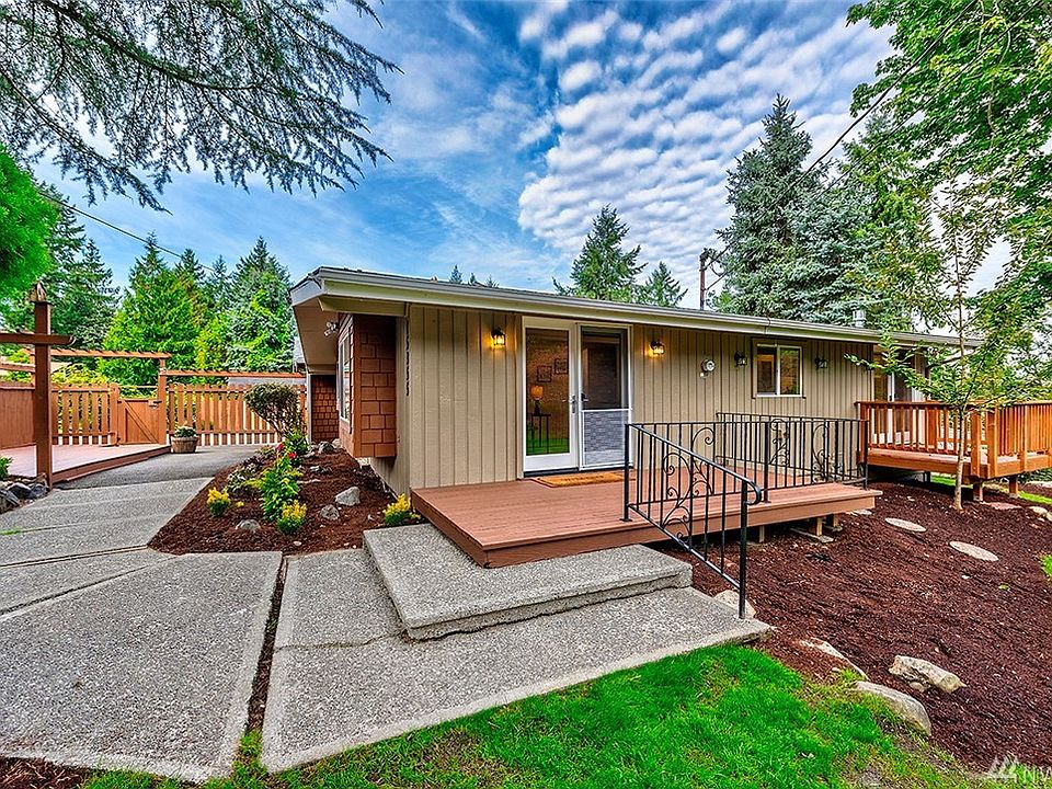 This darling rambler is nestled on a .42 acre lot with 3 decks and yard space all around. This is the view of the front door. You enter the garden through the gate on the left.