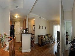 This photo offers a panoramic view of the entry way facing the dining room, kitchen and living room.