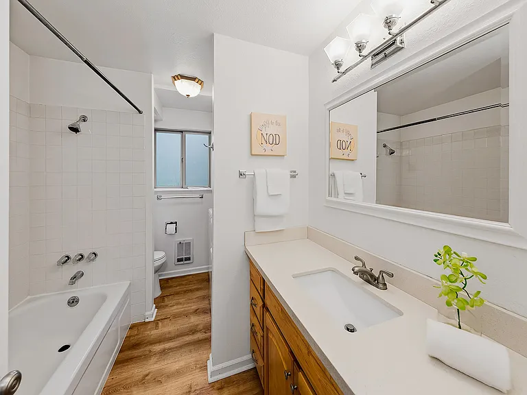 Spacious full bathroom with a maple hardwood vanity, a quartz countertop, an undermount sink, and a new toilet.