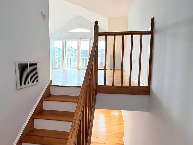Split-level layout with hardwood stairs leading to a bright and open living space.