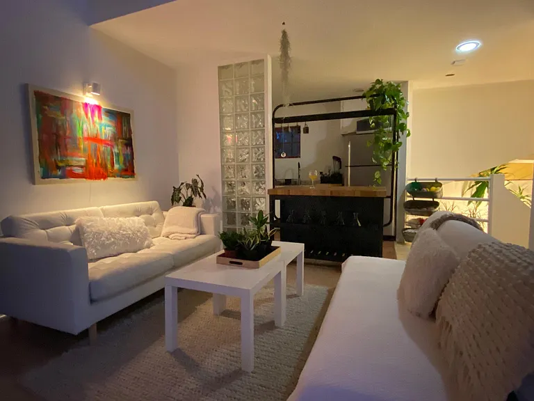 Living area highlighting glass block wall separating kitchen from living area to ensure the stove cannot be seen from the living room.