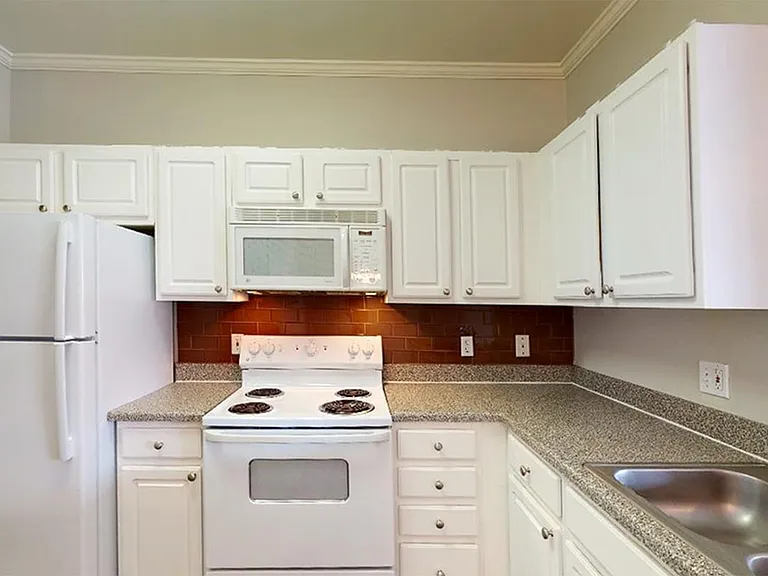Apartment kitchen with wood-style flooring.