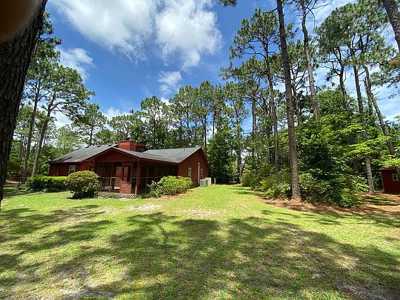Side view of house showing covered porch and large backyard (with beautiful azalea bushes).