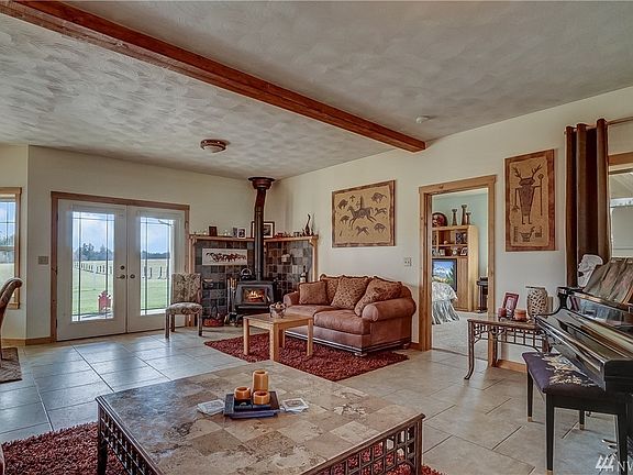 The front entrance is welcomed by an open concept floor plan with ceramic tile floors and pot belly stove. 
