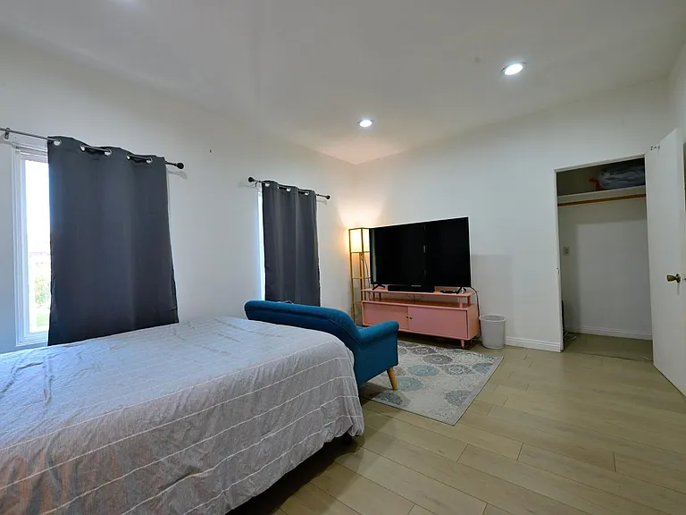 Spacious bedroom with queen sized bed and mattress, cute sofa, 65" 4k TV and wifi included