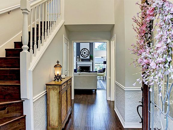 Your view as you enter this lovely home. Updated hardwood flooring, neutral paint and a view out to the back yard space and pool