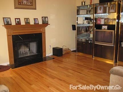 Family room
						:
						with wood floors and marble fire place