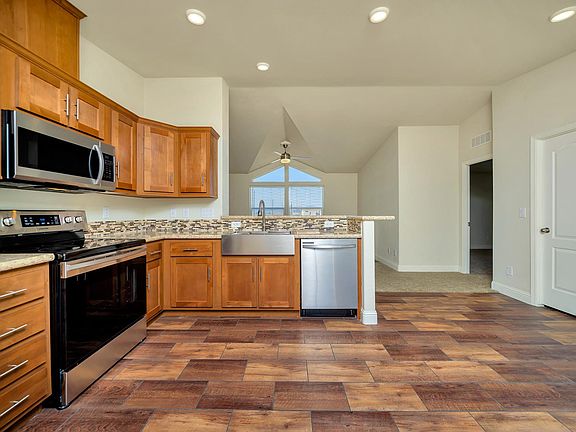 Kitchen - Solid wood cabinets, upgraded nickel hardware, title back splashes, highly upgraded stainless appliance package, center island, and country farm sink with pull-out faucet, recessed lighting.
